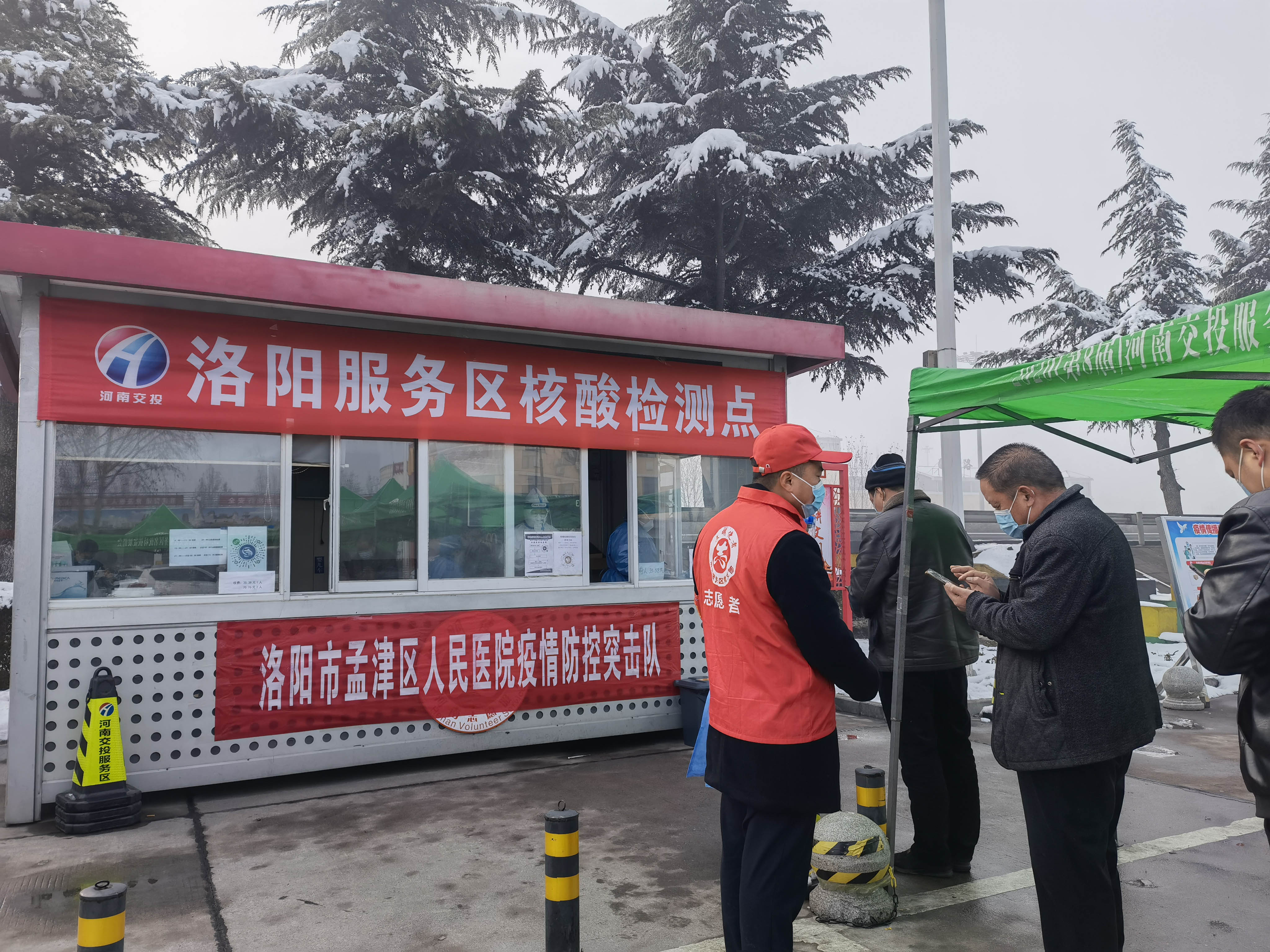 1月25日，洛陽服務區(qū)黨員志愿者為指引司乘人員填寫核酸檢測信息。 周黃偉 攝.jpg